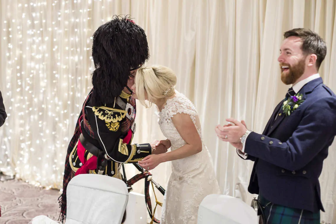 Bride kissing the piper at reception