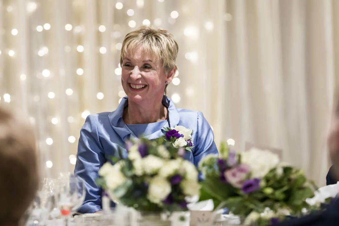 Mother of the bride smiling at the top table