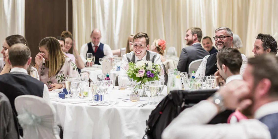 Guests laughing during speeches at reception