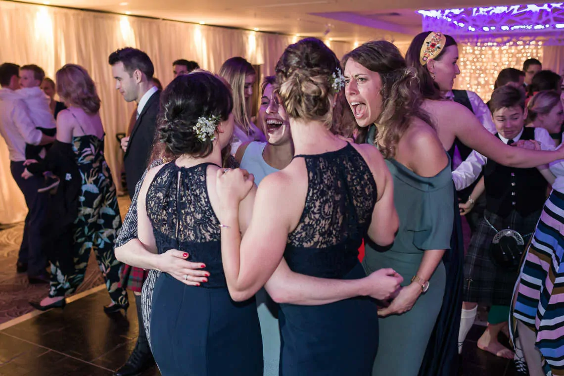 Bridesmaids and guests dancing at evening reception