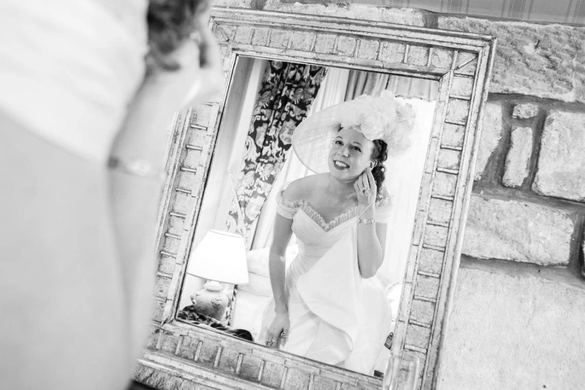 bride puts in her earrings in front of a mirror in one of the castle's suites