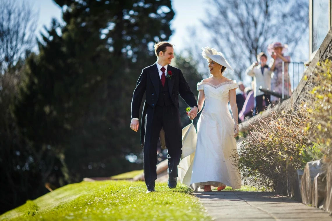 newlyweds walking together on a path in the castle grounds
