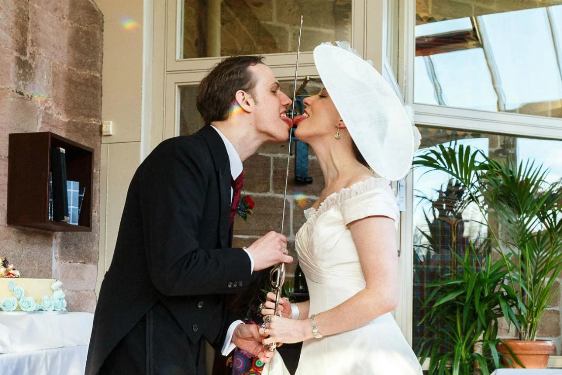 newlyweds licking the sword after cutting the cake in The Orangery