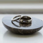 bride and groom's wedding rings sat on an ammonite fossil