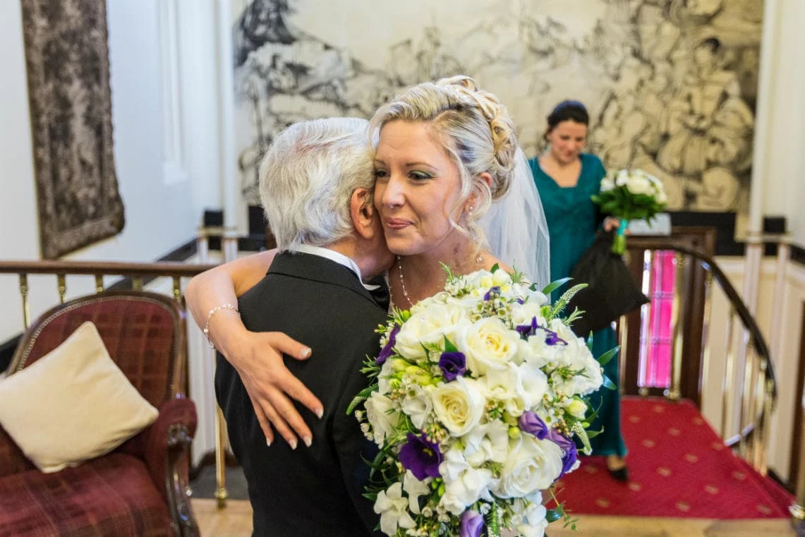 bride embraced by her father a few minutes before she gets married