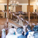 bridal party make their way down the stairs in the chapel
