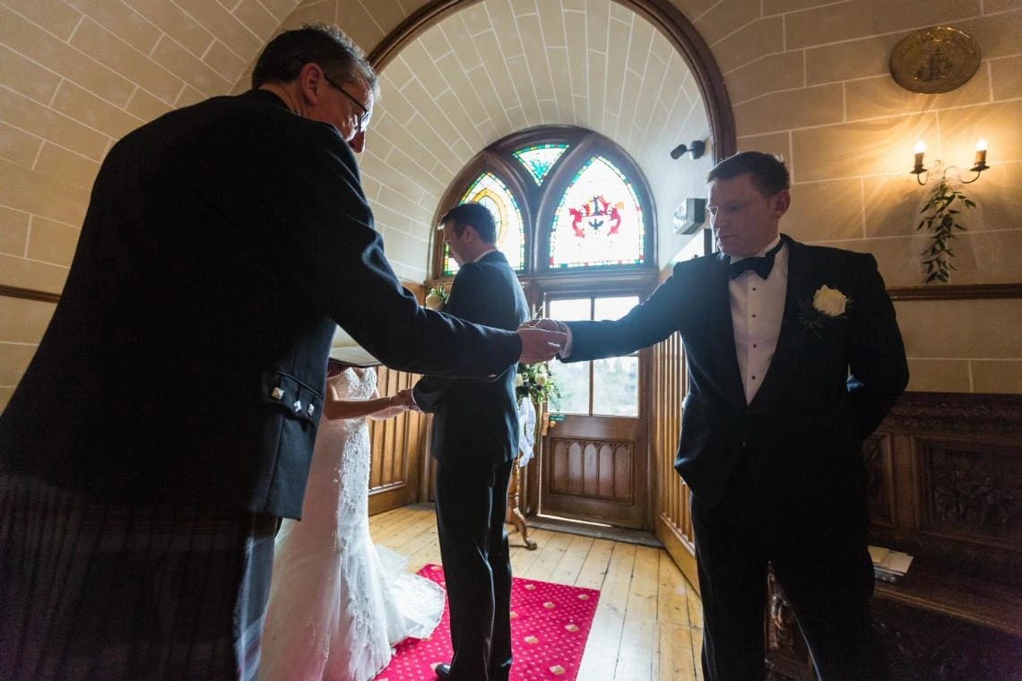 best man hands wedding rings to the celebrant