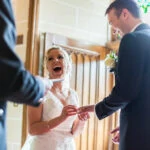 bride laughing during the exchange of rings and vows in the chapel