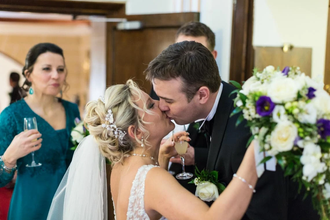 groom kisses his bride outside the chapel entrance