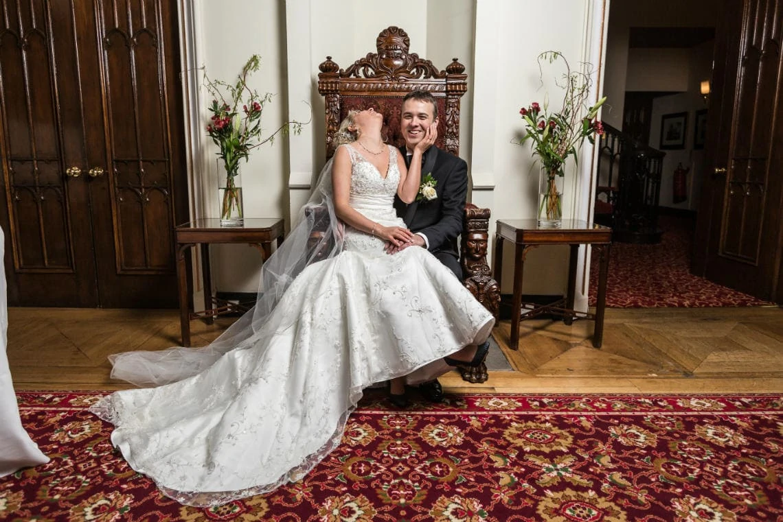 newlyweds sitting on the throne on the castle landing