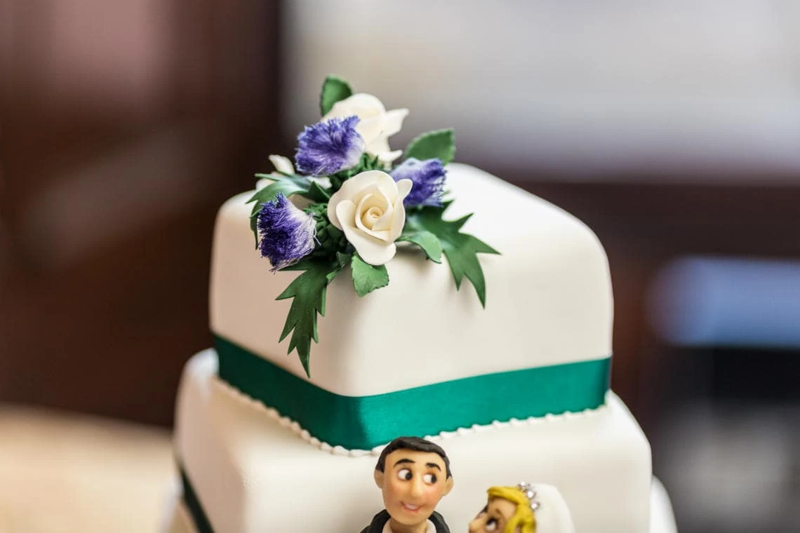 white wedding cake with green ribbons and flower decoration