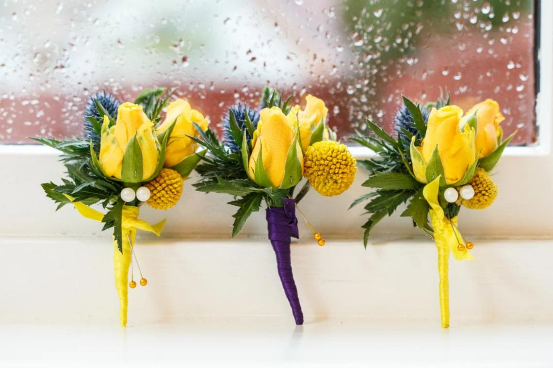 yellow rose with blue thistle buttonholes