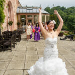 bride throws her bouquet on the castle's patio