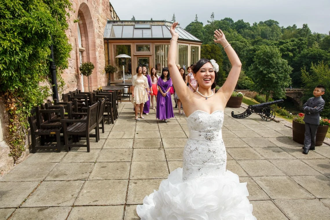 bride throws her bouquet on the castle's patio