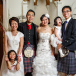 newlyweds and family group photo in the reception area of the castle