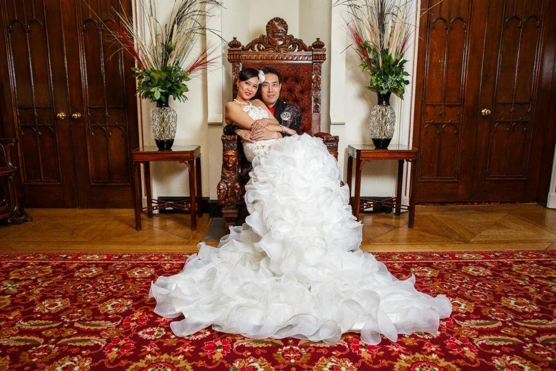newlyweds embrace on the throne in the reception area of the castle