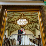 newlyweds mirror reflection standing in front of the mural in the reception area