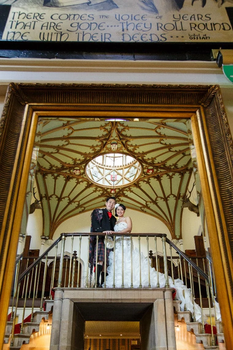 newlyweds mirror reflection standing in front of the mural in the reception area