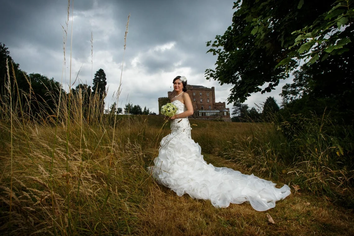 bridal pose in the meadow with the castle in the background