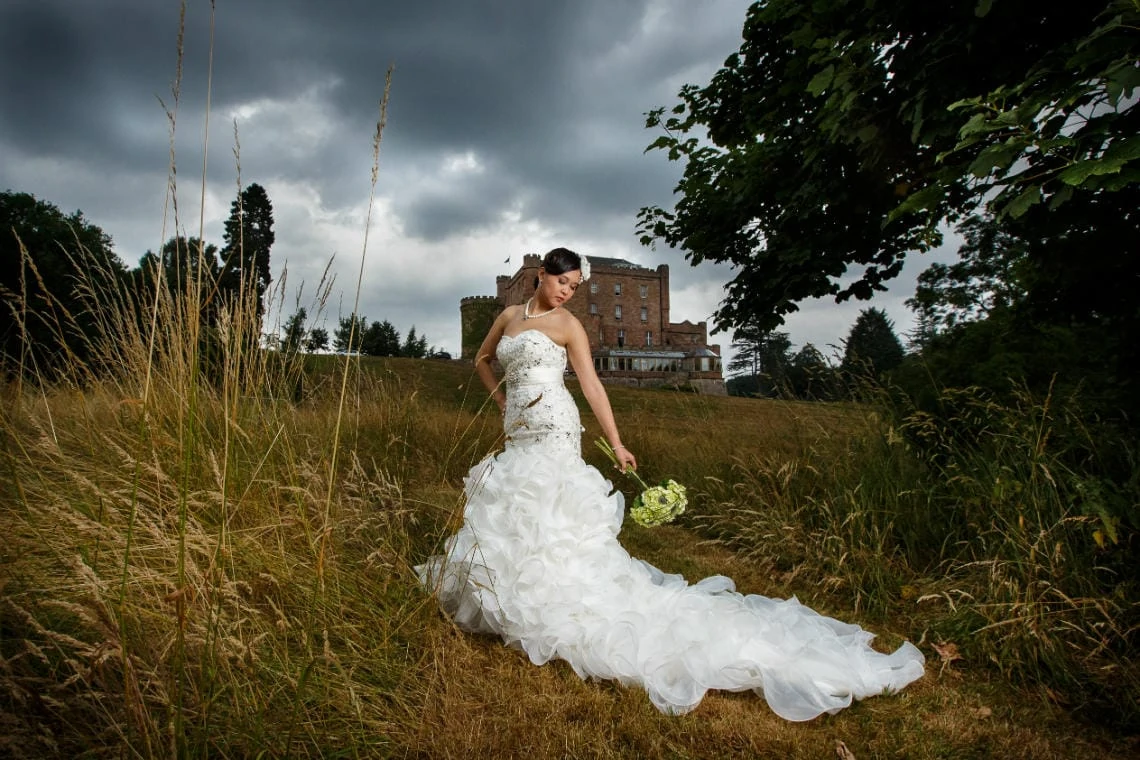 bridal pose in the meadow with the castle in the background