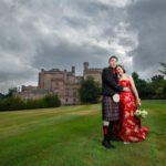 newlyweds embrace on the lawn in front of the castle