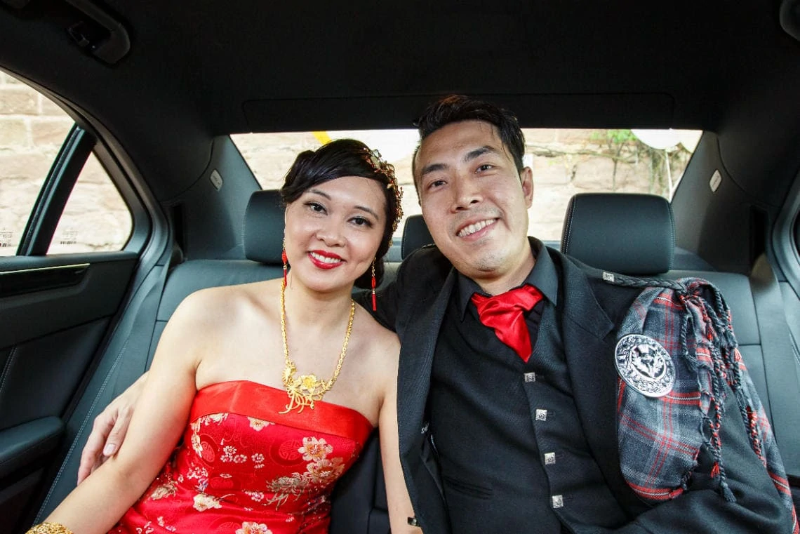 newlyweds sitting in the back of their wedding car