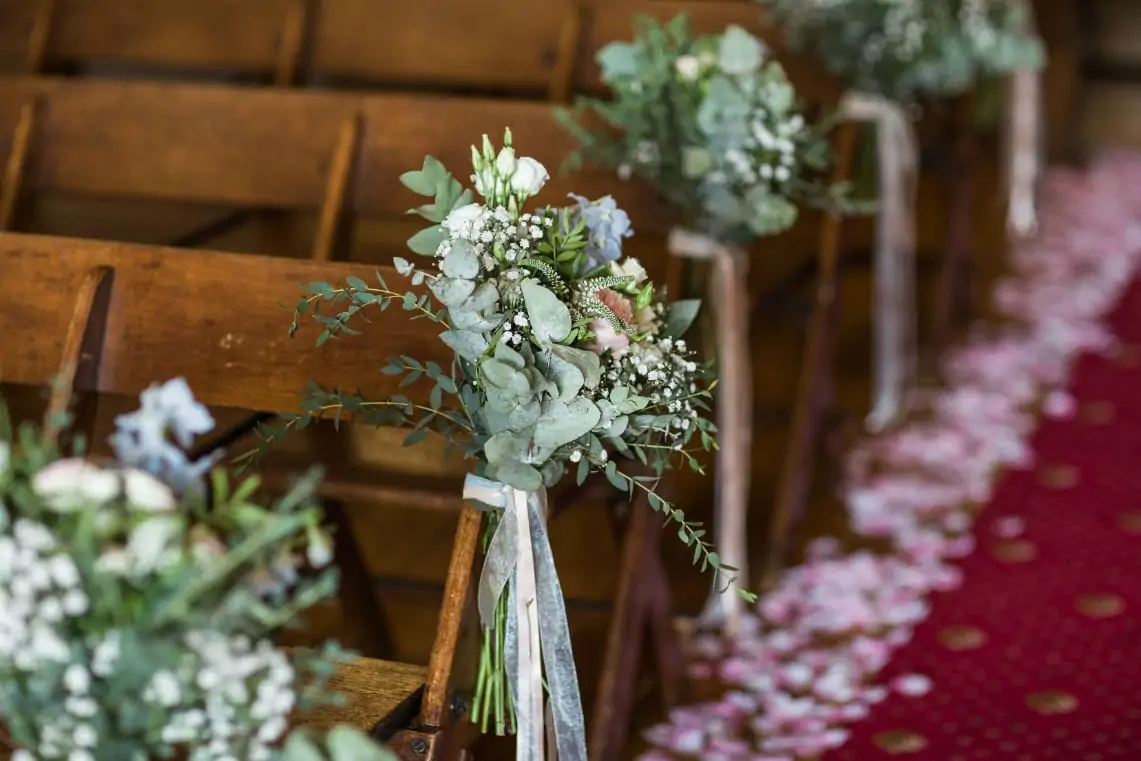 Flowers tied to wooden seats in the Chapel.