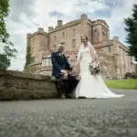 Bride and Groom with Dalhousie castle in the background.
