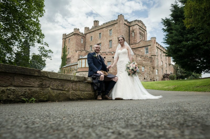 Bride and Groom with Dalhousie castle in the background.