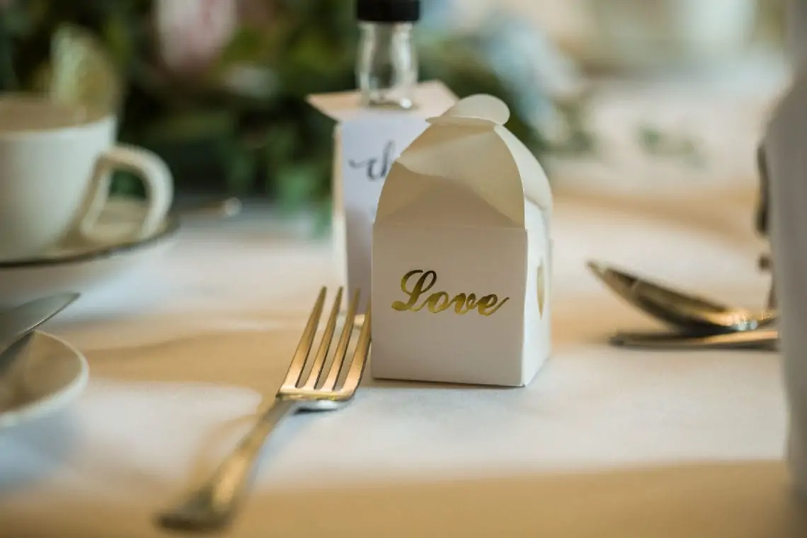 Small white favour box with love written in gold letters.