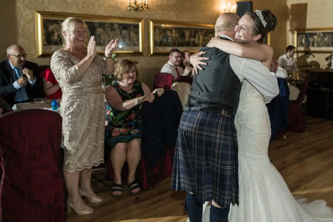 Bride and Dad cuddle after dancing together in The Sir Alexander Suite.