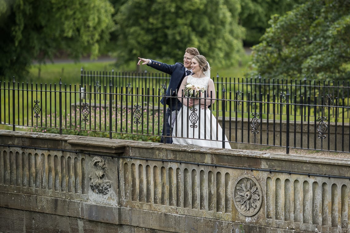 newlyweds standing on the arched bridge at Dalmahoy Hotel
