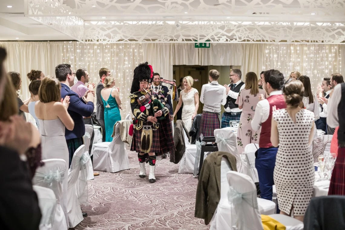 Dalmahoy Suite - piper leads the newlyweds to the top table