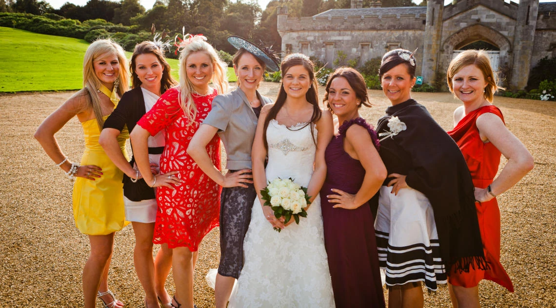 bride and female friends group photo at the front of the castle