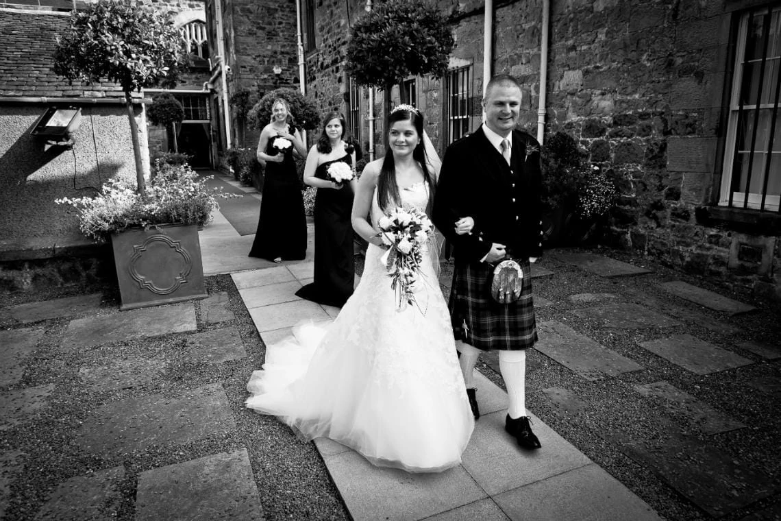Bride, father of the bride and bridesmaids walking to the Auld Keep for the ceremony