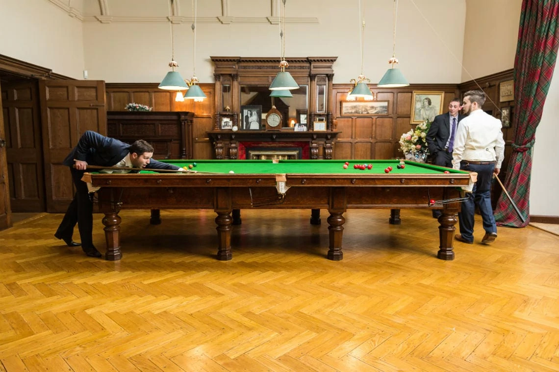 groom and best man playing snooker in the Billiards Room