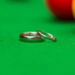 bride and groom's rings on the snooker table