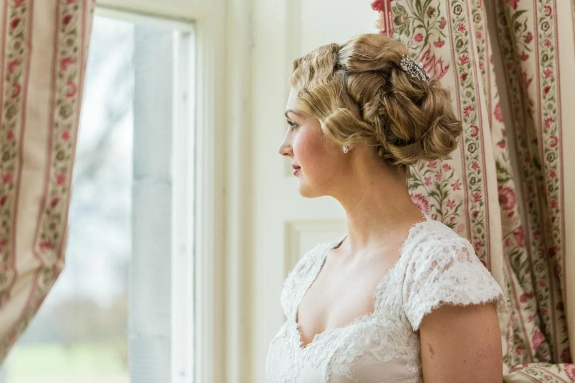 profile portrait of bride looking out of the window in the Winter bedroom