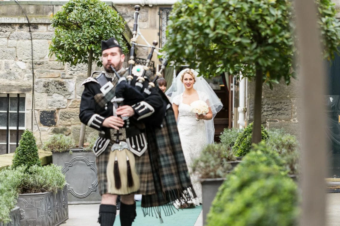 bride is led by the piper to the Auld Keep