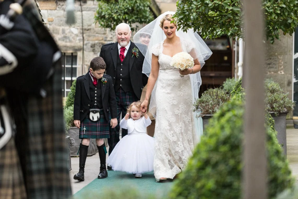 bride, her father, daughter and nephew are led by the piper to the Auld Keep