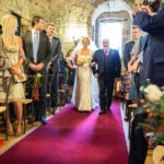 bride escorted by her father up the aisle in the Auld Keep