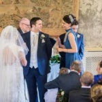 female guest smiles at the bride and groom at the end of her reading in the Auld Keep