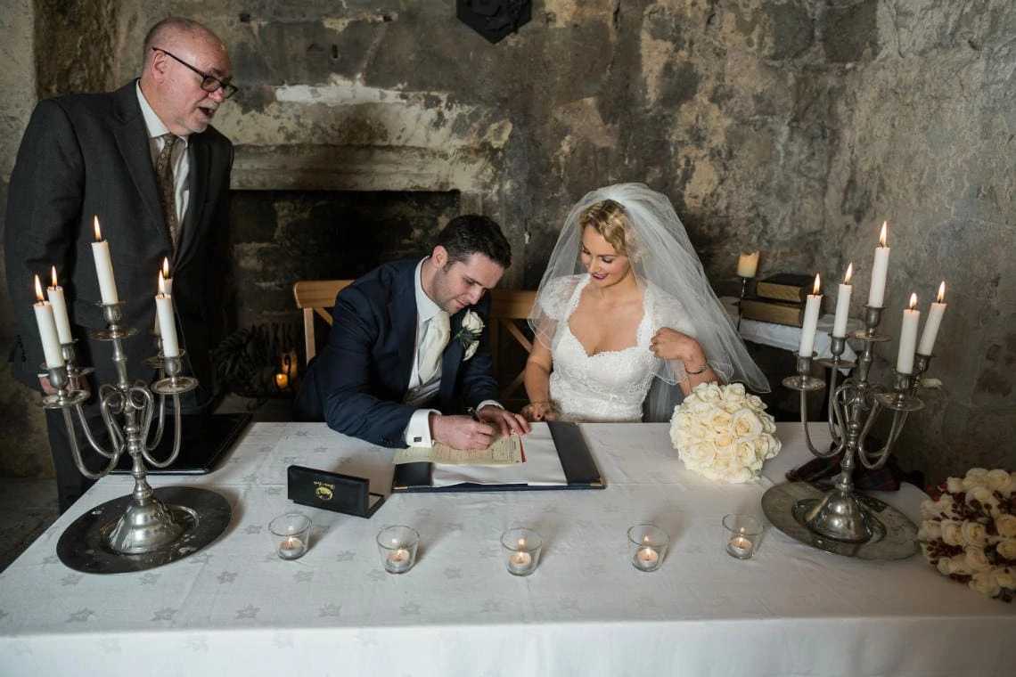 newlyweds signing the marriage schedule in the Auld Keep annex