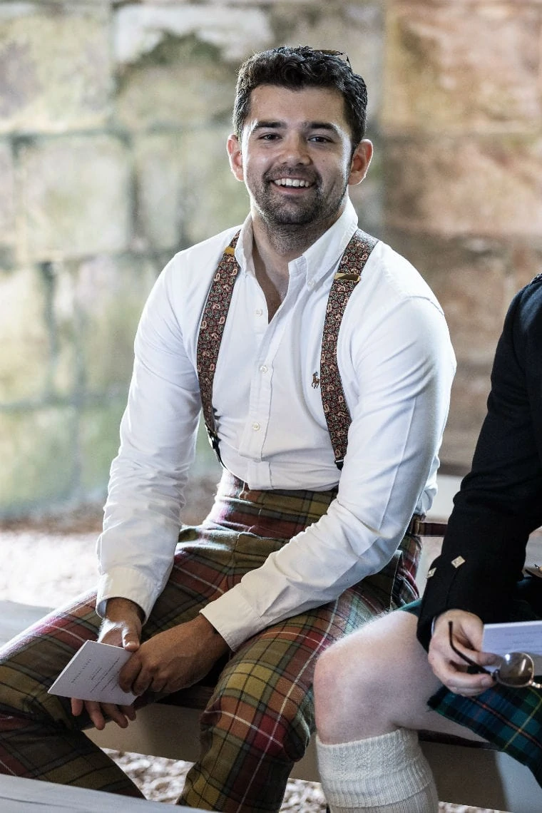 male guest in tartan trews smiling at the camera