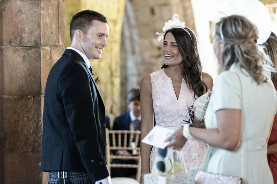 groom smiles as he chats to female guests