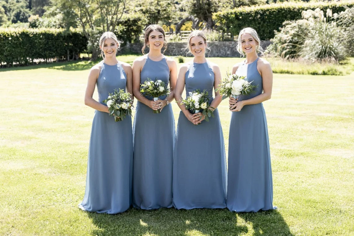 bridesmaids in pale blue dresses in the sun