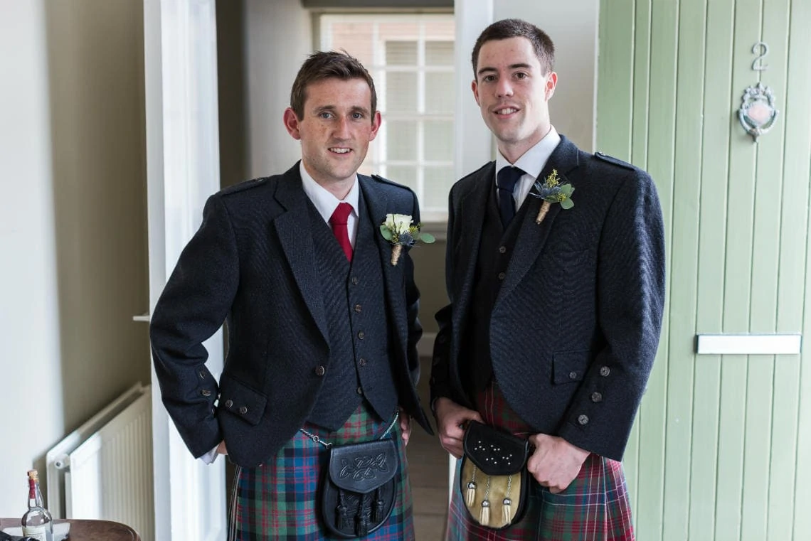 groom and groomsman at the door of Birch Cottage