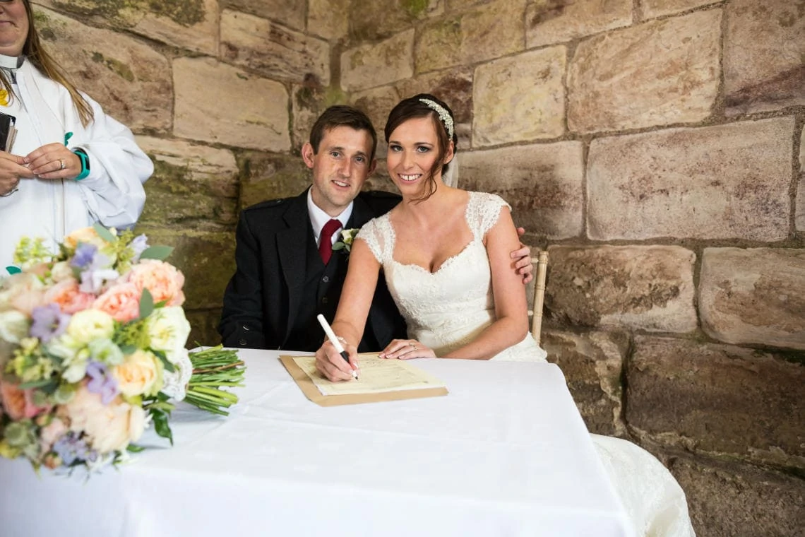 newlyweds signing the marriage schedule in the church