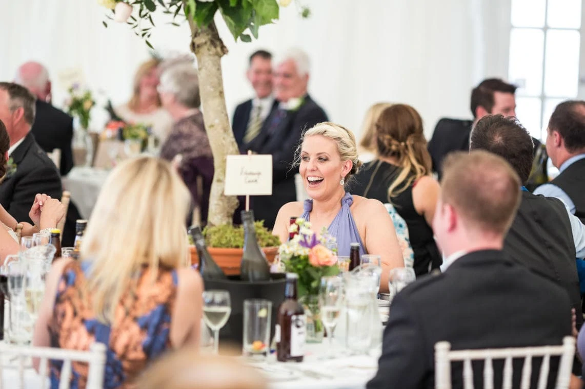 bridesmaid laughing during the best man's speech