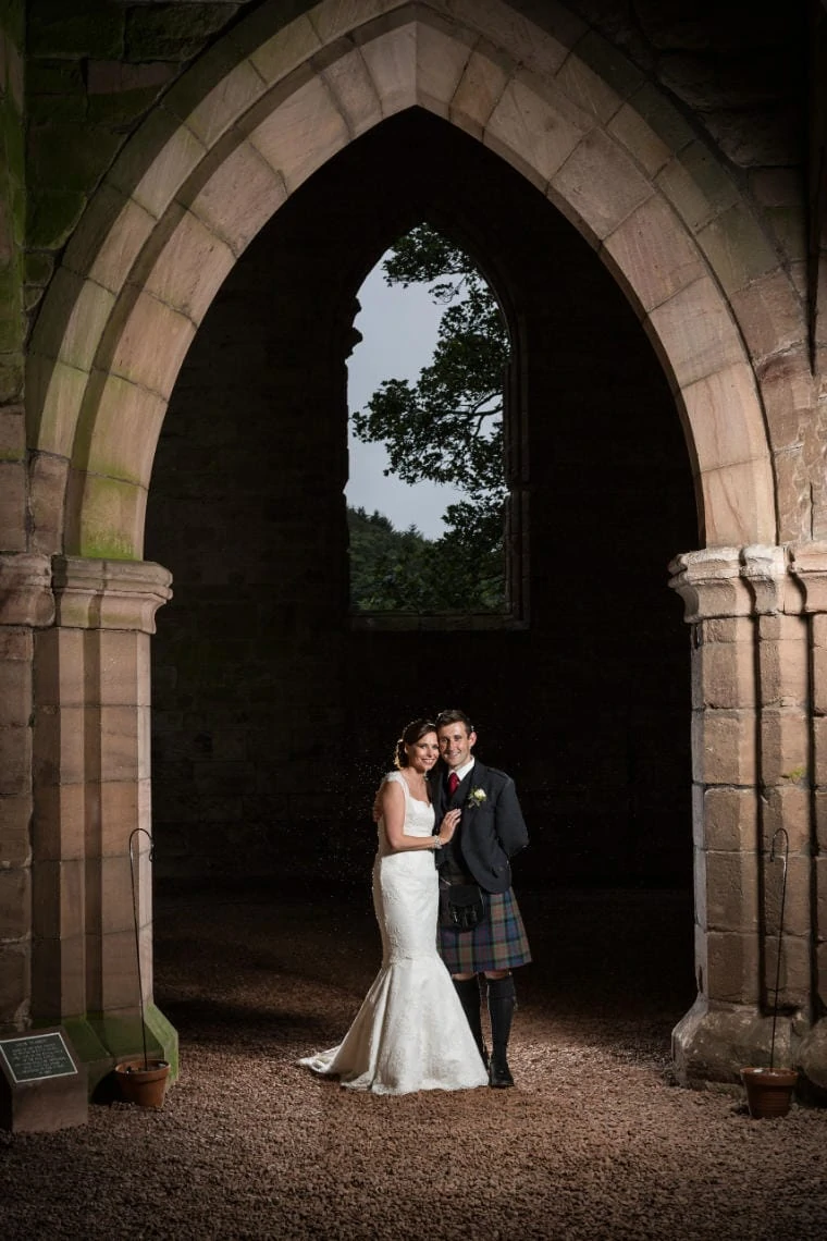 bride and groom pictured in Dunglass Church in the evening